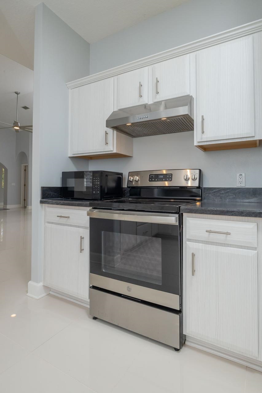 573 Boxwood Place St. Augustine, FL 32086 - Photo 22 of 40 a kitchen with granite countertop white cabinets and stainless steel appliances