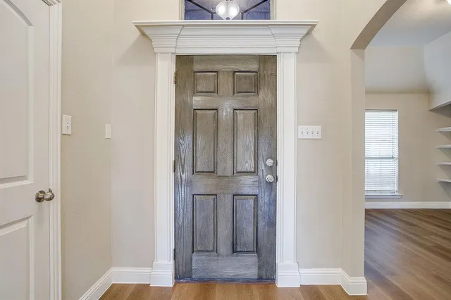 a view of a hallway with wooden floor and closet