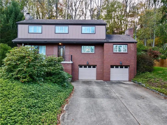 a front view of a house with yard and trees