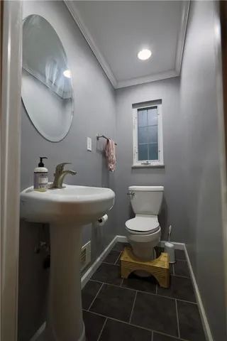 a bathroom with a toilet sink and mirror