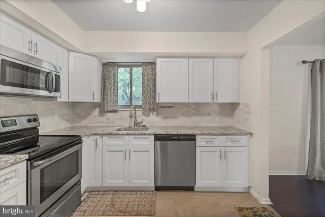 a kitchen with stainless steel appliances granite countertop a sink stove a microwave and cabinets