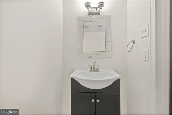 a bathroom with a sink a light fixture and a mirror
