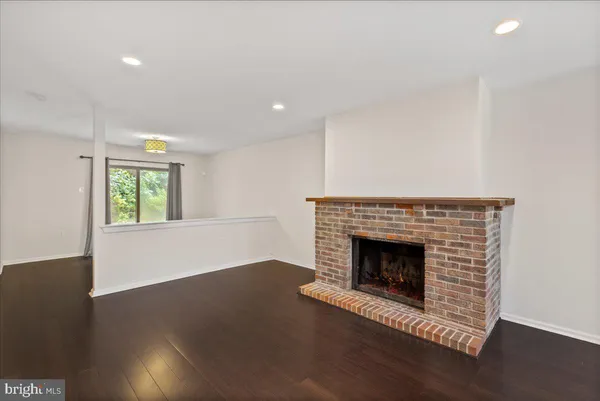 a living room with a fireplace and wooden floor