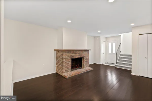 an empty room with wooden floor and fireplace