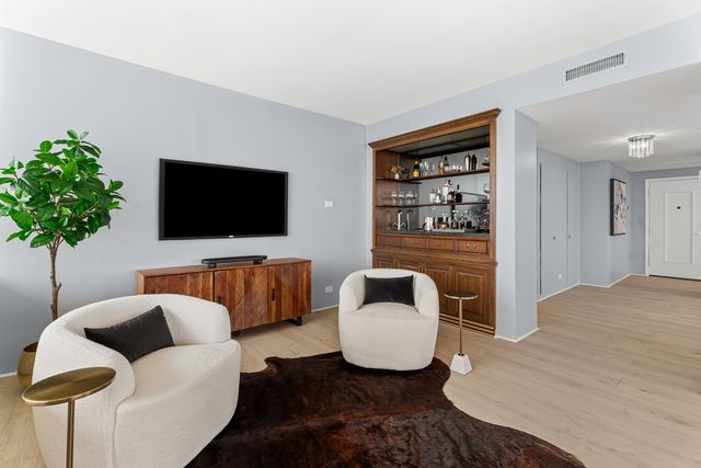 a kitchen with stainless steel appliances a table chairs refrigerator and sink