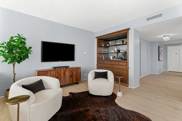 a kitchen with stainless steel appliances a table chairs refrigerator and sink