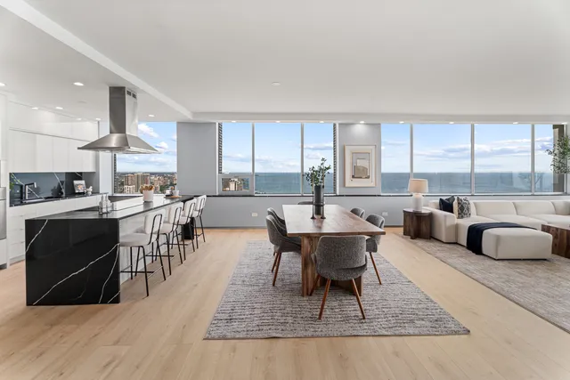 a kitchen with stainless steel appliances kitchen island granite countertop a refrigerator a stove and a sink with wooden floor