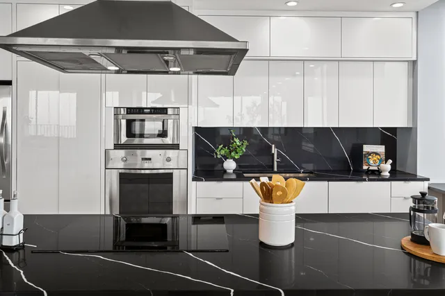 a large kitchen with stainless steel appliances a large counter top and a stove