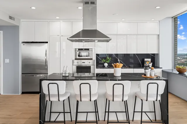 a kitchen with kitchen island granite countertop a sink counter top space cabinets and stainless steel appliances