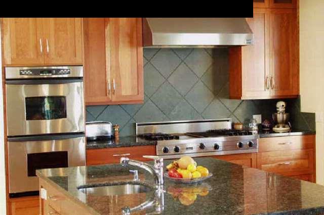 155 Pulehu Road Kula, HI 96790 - Photo 10 of 18 a kitchen with stainless steel appliances granite countertop a stove and white cabinets with wooden floor