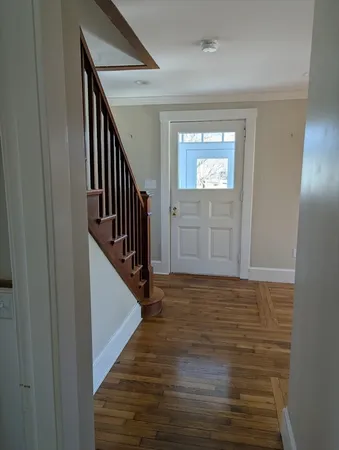 a view of a hallway with wooden floor and staircase