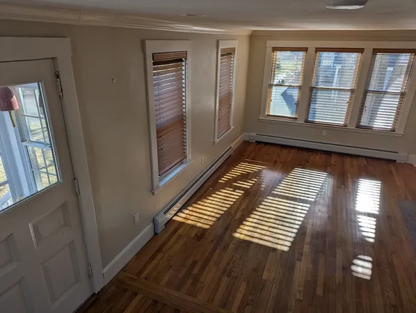 a view of wooden floor in a hall with an entryway