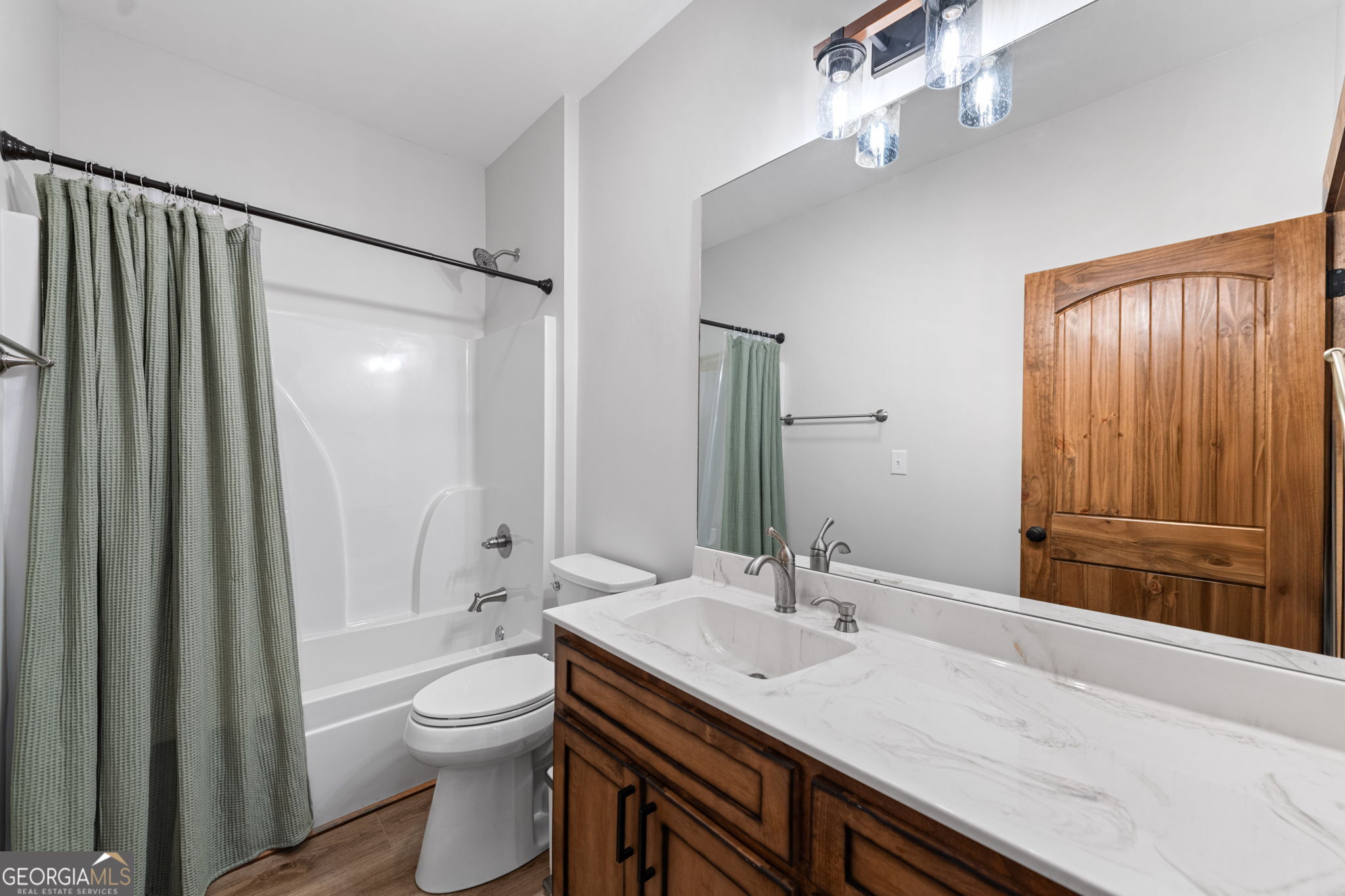 120 Cohutta Ranch Road Blue Ridge, GA 30513 - Photo 56 of 90 a bathroom with a granite countertop sink a toilet a mirror and shower