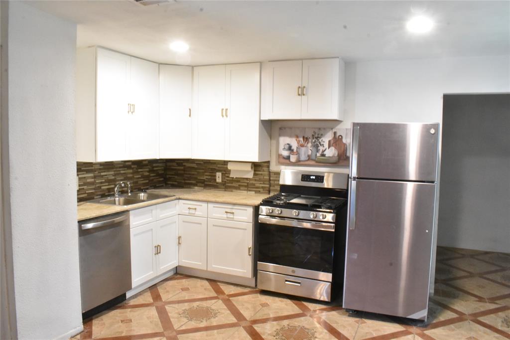 6040 Prothrow Street Fort Worth, TX 76112 - Photo 2 of 8 a kitchen with white cabinets and stainless steel appliances