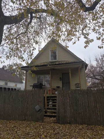 a front view of a house with a tree