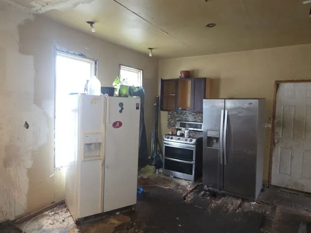 a white refrigerator freezer and a stove sitting inside of a kitchen