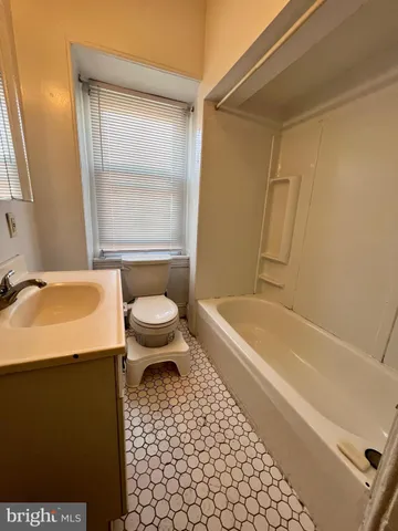 a bathroom with a granite countertop toilet a sink and a bathtub