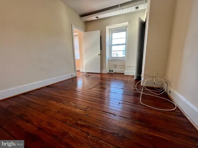 a view of room with wooden floor and gym equipment