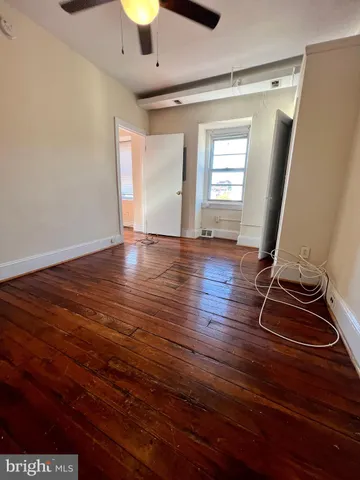 a view of room with wooden floor and windows