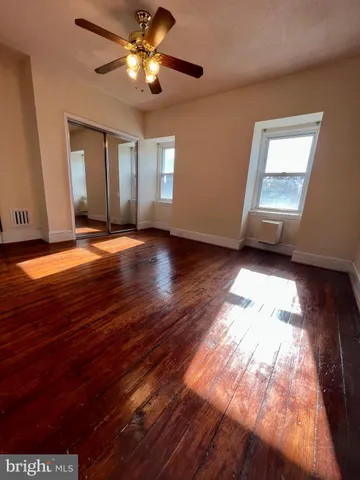 a view of a livingroom with wooden floor and a ceiling fan