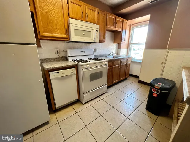 a kitchen with a sink a stove top oven and cabinetry