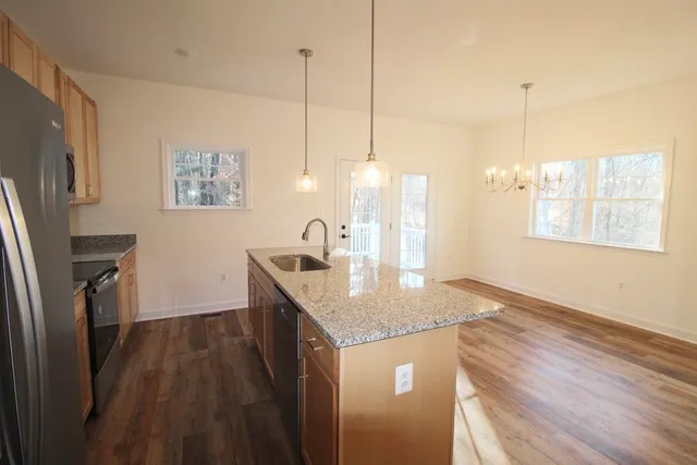 a kitchen with granite countertop a sink a counter top space and cabinets