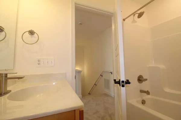 a bathroom with a tub shower vanity and a sink