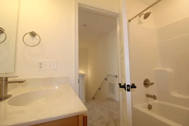 a bathroom with a tub shower vanity and a sink