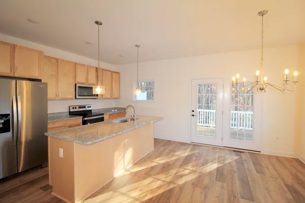 a kitchen with stainless steel appliances granite countertop a refrigerator a stove a sink and a center island