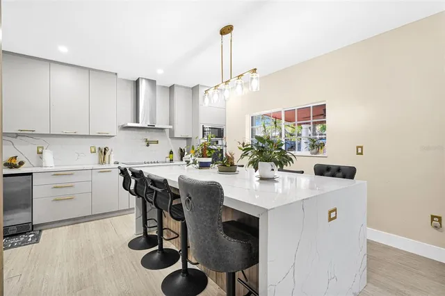 a living room with furniture and a open kitchen view