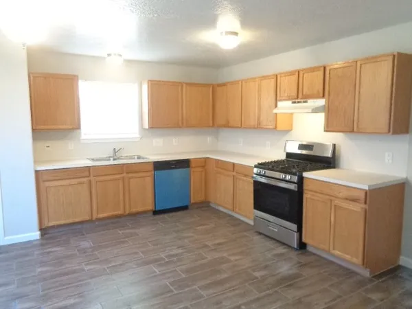 a kitchen with a sink stove top oven and cabinets