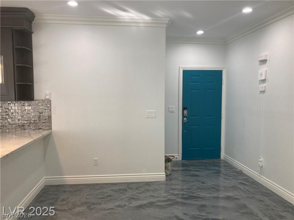9050 West Warm Springs Road, Unit 1027 Las Vegas, NV 89148 - Photo 8 of 44 A vibrant teal door invites entry into a space featuring sleek recessed lighting and decorative crown molding.
