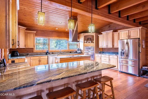 a wooden floor with glass top table and chairs