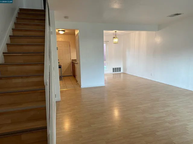 a view of a hallway with wooden floor and staircase