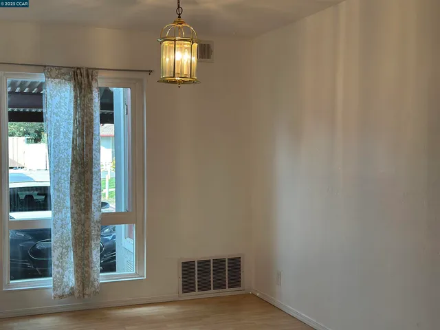 a view of livingroom with chandelier fan and hallway