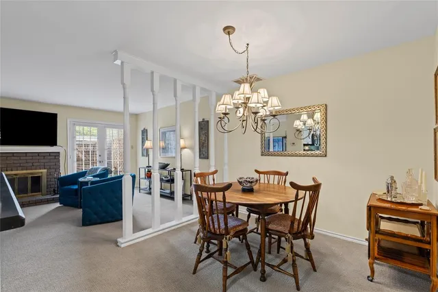 a view of a dining room with furniture a chandelier and wooden floor
