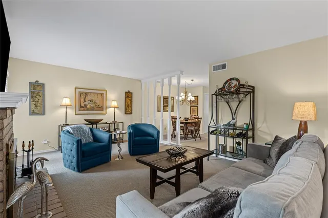 a living room with furniture a rug and a lamp