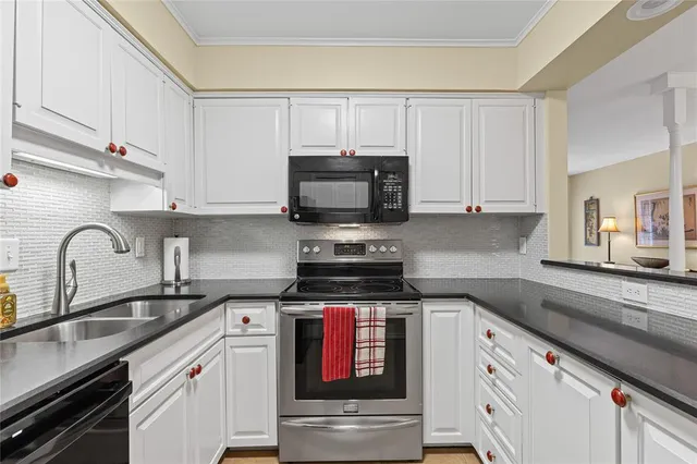 a kitchen with granite countertop white cabinets and stainless steel appliances