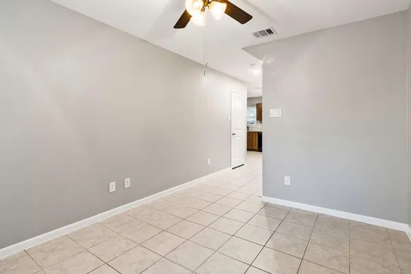 an empty room and chandelier fan
