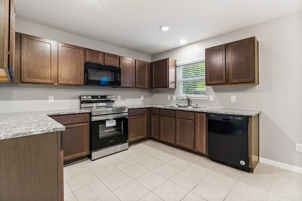 a kitchen with stainless steel appliances granite countertop a stove microwave and sink