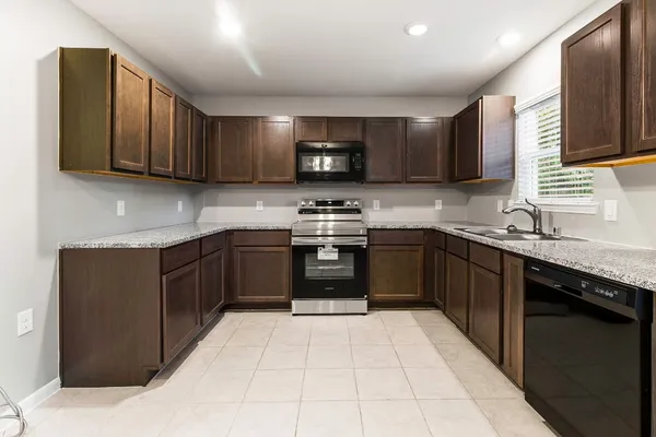 a kitchen with a sink a stove top oven and cabinets