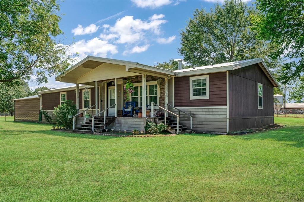 a view of a house with a yard and sitting area