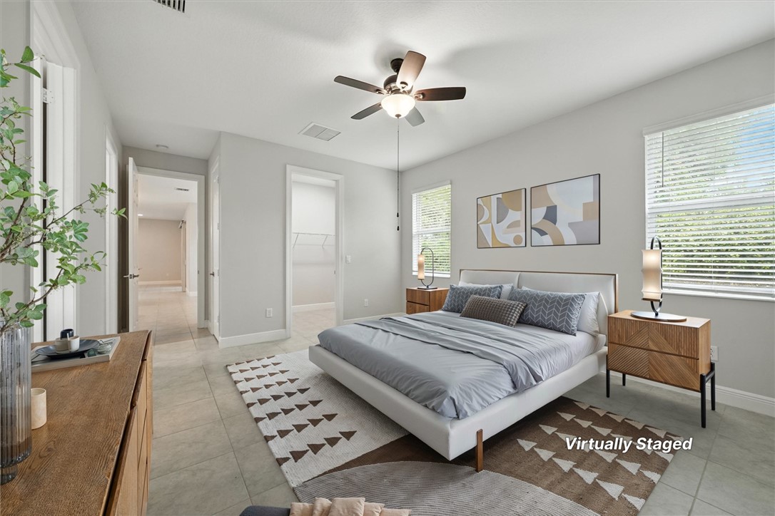 6096 Bella Rosa Lane Vero Beach, FL 32966 - Photo 17 of 33 a bedroom with a large bed and a chandelier