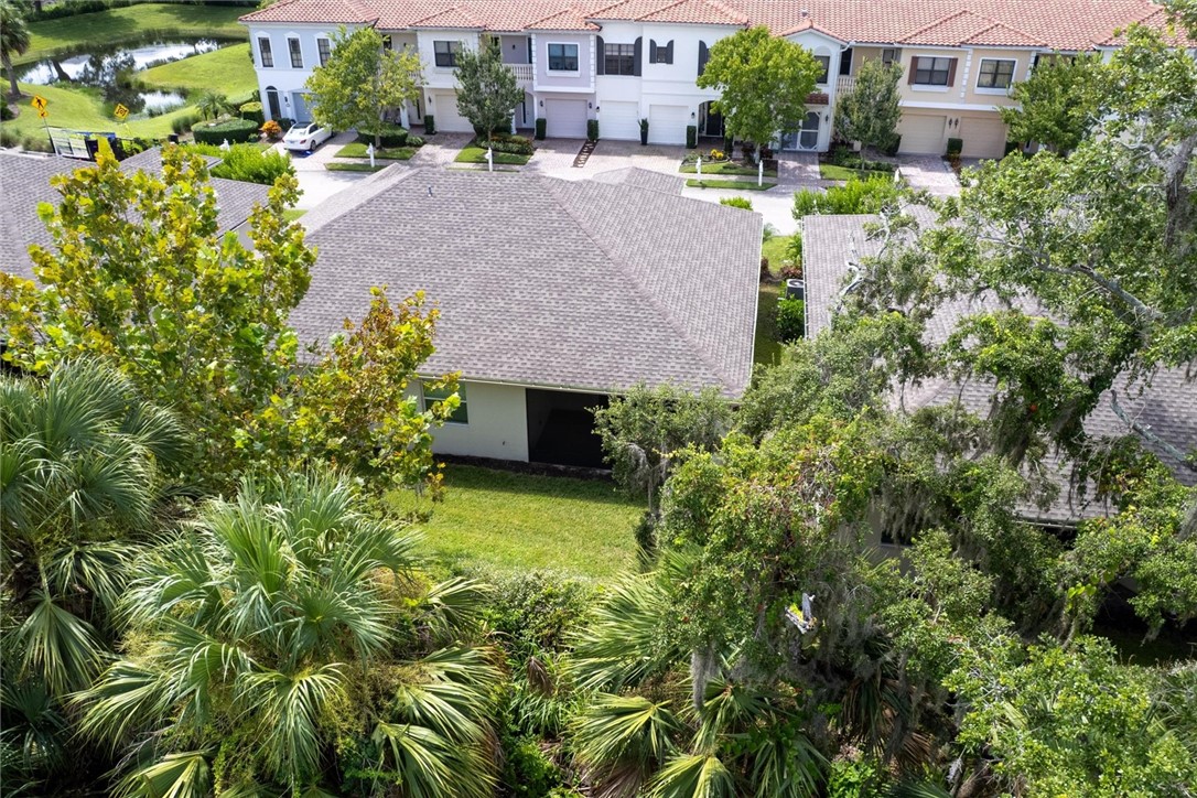 6096 Bella Rosa Lane Vero Beach, FL 32966 - Photo 25 of 33 an aerial view of a house with a yard and large trees