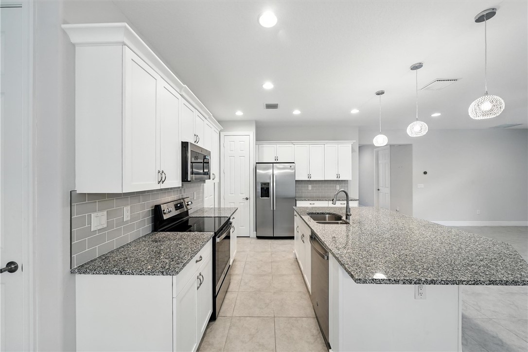 6096 Bella Rosa Lane Vero Beach, FL 32966 - Photo 5 of 33 a kitchen with a sink stove and refrigerator