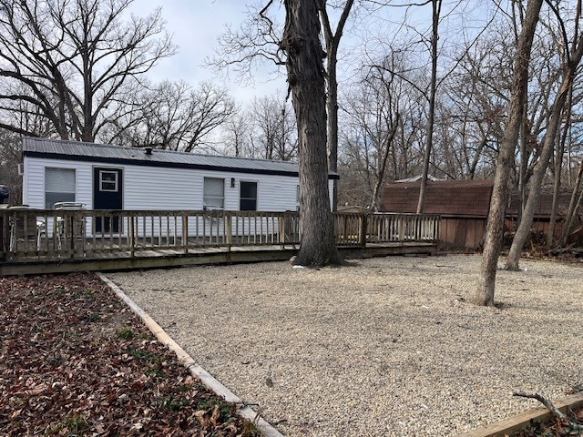 2795 East 28th Road Marseilles, IL 61341 - Photo 20 of 62 a view of wooden house with a yard covered with snow in the background