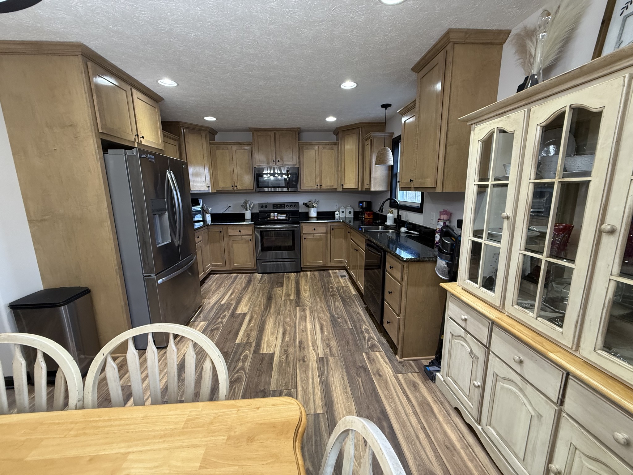 108 Checker Lane Lafayette, TN 37083 - Photo 5 of 15 a kitchen with stainless steel appliances granite countertop a refrigerator a stove top oven a sink dishwasher and wooden floor