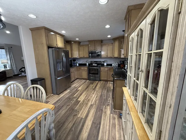 a kitchen with stainless steel appliances granite countertop refrigerator sink stove microwave and cabinets