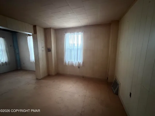 a view of an empty room with a fireplace and a window