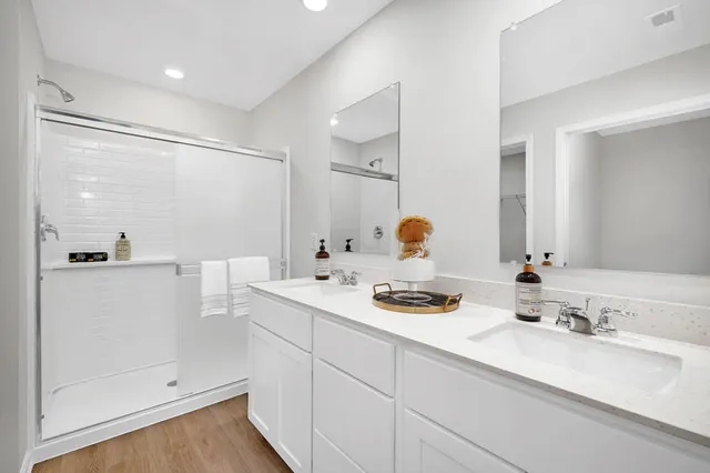 a bathroom with a sink vanity granite tub shower and a mirror